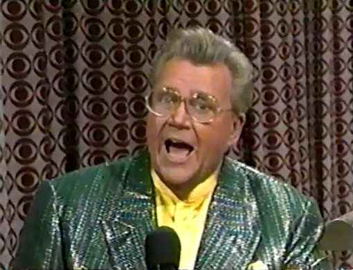 Rod is wearing a green sequined jacket & yellow collarless silk shirt with matching pocket square
