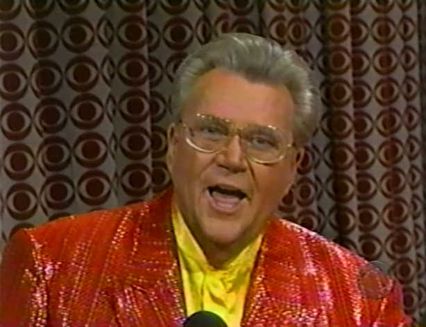 Rod is wearing a red sequined jacket & yellow collarless silk shirt