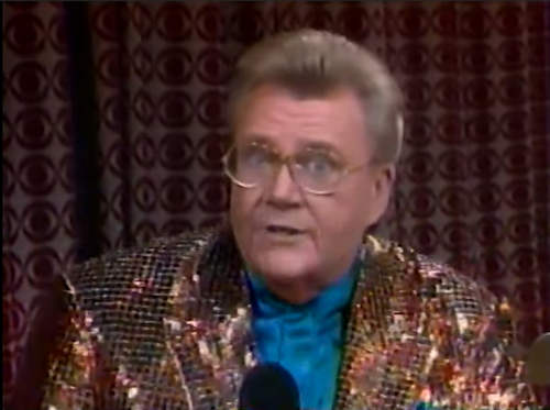 Rod is wearing a brown sequined jacket & teal-blue collarless silk shirt