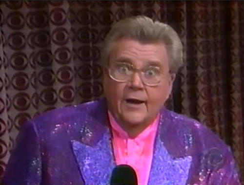 Rod is wearing a purple sequined jacket & pink collarless silk shirt