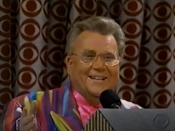 Rod is wearing a striped multi-colored jacket & pink collarless silk shirt