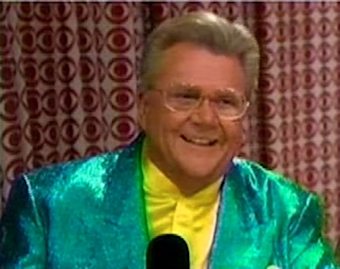 Rod is wearing a shiny-green jacket & yellow silk collarless shirt