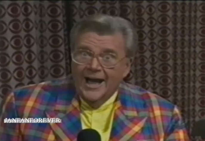 Rod is wearing a multi-colored gingham jacket & yellow collarless silk shirt