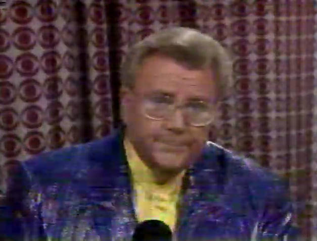 Rod is wearing a purple sequined jacket & yellow collarless silk shirt