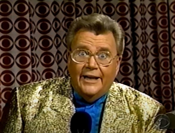 Rod is wearing a shiny gold jacket & blue collarless silk shirt