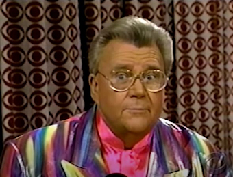 Rod is wearing a shimmery rainbow jacket & pink silk collarless shirt