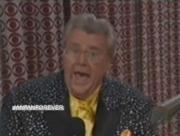 Rod is wearing a black 'mottled' jacket & yellow collarless silk shirt w/ matching pocket square