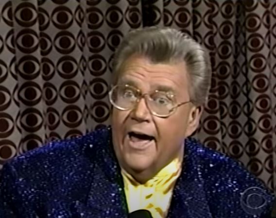 Rod is wearing a dark-blue sequined jacket & yellow collarless silk shirt