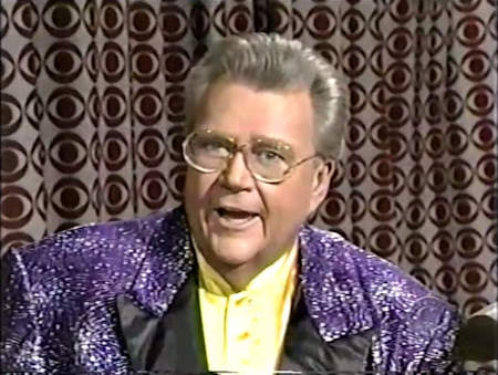 Rod is wearing a sparkly purple jacket with black lapels & yellow collarless silk shirt