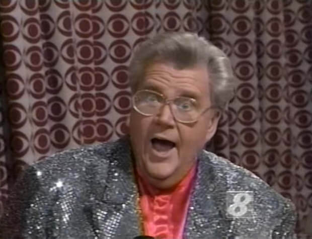 Rod is wearing a silver sequined jacket & salmon collarless silk shirt