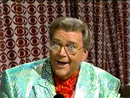 Rod is wearing a green sequined jacket & red collarless silk shirt