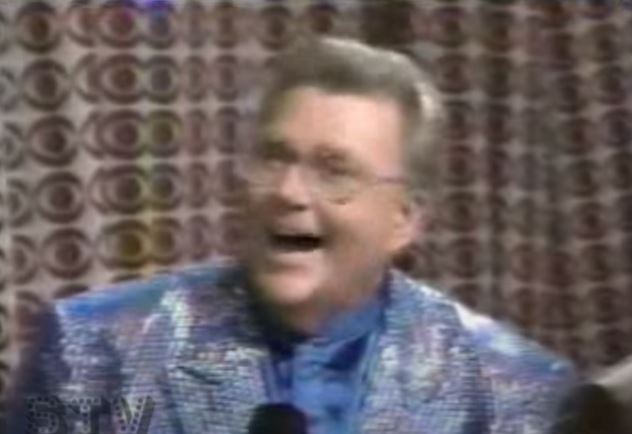 Rod is wearing a grey sequin jacket & periwinkle collarless silk shirt