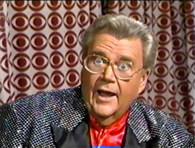 Rod is wearing a black jacket with silver sequins & black lapels with a red collarless silk shirt