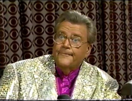 Rod is wearing a gold sequined jacket & fuchsia collarless silk shirt