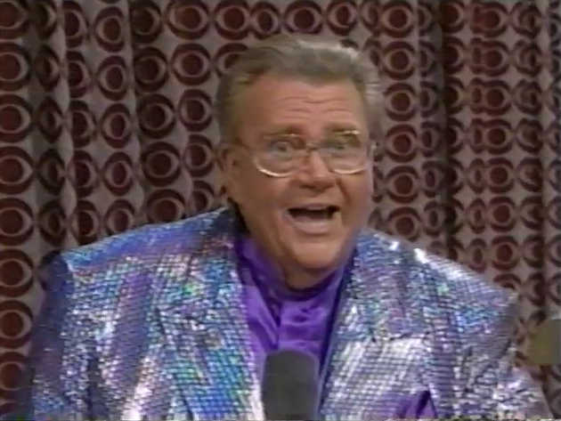 Rod is wearing a silver-iridescent sequin jacket & purple collarless silk shirt with matching pocket square
