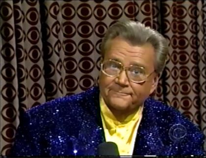 Rod is wearing a blue sequined jacket & yellow collarless silk shirt