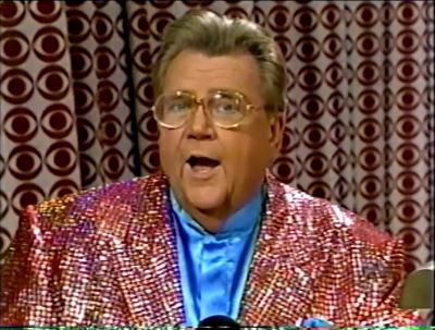Rod is wearing an iridescent red sequined jacket & powder-blue collarless silk shirt with matching pocket square