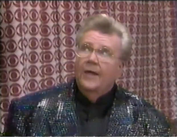 Rod is wearing a black sequined jacket & black collarless silk shirt
