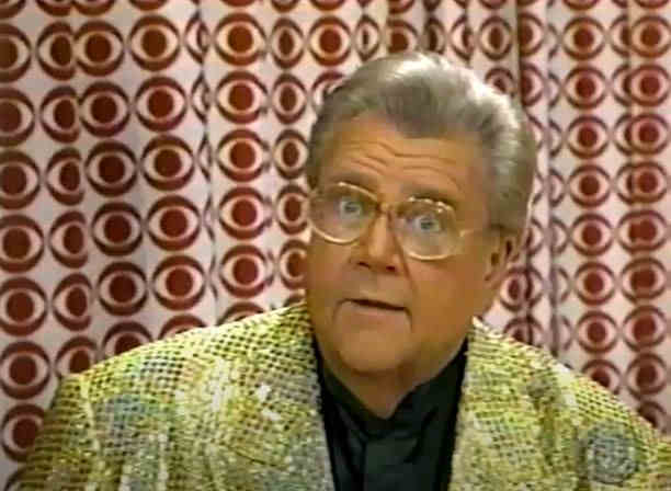 Rod is wearing a gold sequined jacket & black collarless silk shirt