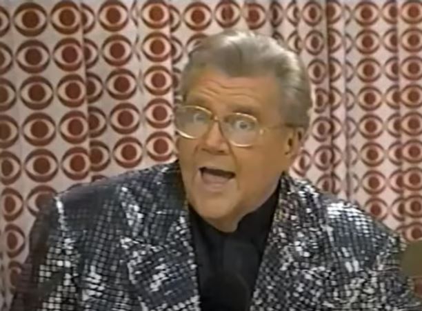 Rod is wearing a silver sequined jacket & black collarless silk shirt