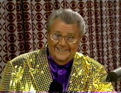 Rod is wearing a yellow jacket with black sequins & purple collarless silk shirt