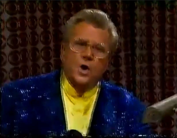 Rod is wearing a dark-blue sequined jacket & yellow collarless silk shirt