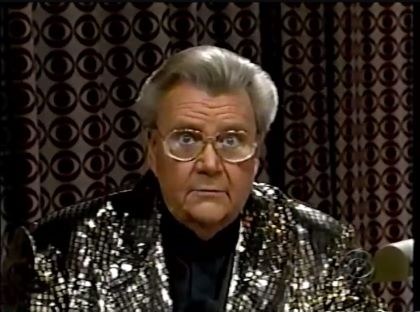 Rod is wearing a black jacket with silver sequins & black collarless silk shirt