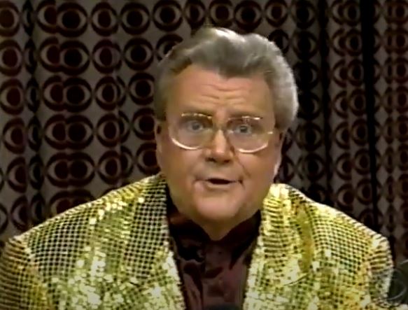 Rod is wearing a gold sequined jacket & brown collarless silk shirt