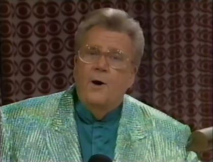 Rod is wearing a shiny green/green-striped jacket & dark-green collarless silk shirt