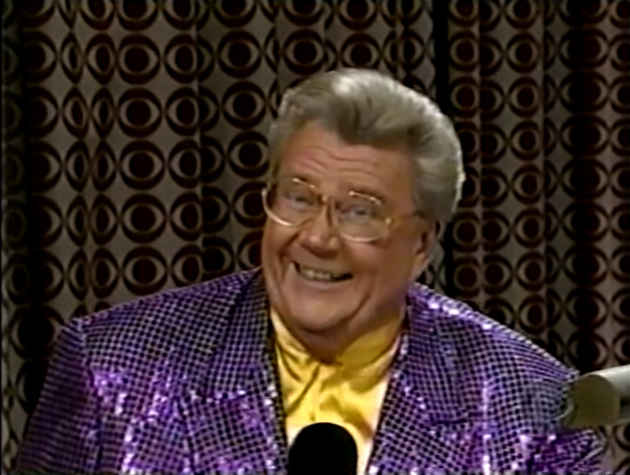 Rod is wearing a purple sequined jacket & yellow collarless silk shirt