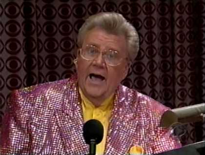 Rod is wearing a pink sequin jacket & yellow collarless silk shirt with matching pocket square
