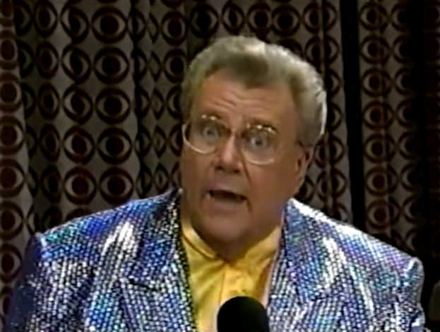 Rod is wearing a shiny silver-dotted jacket & yellow collarless silk shirt