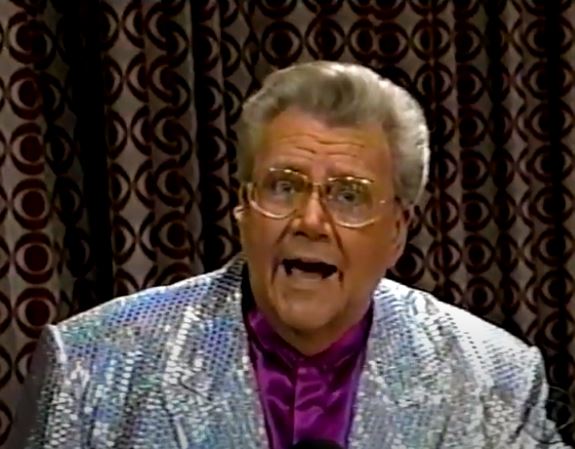 Rod is wearing a silver sequined jacket & purple collarless silk shirt