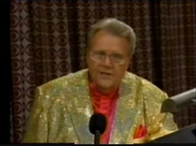 Rod is wearing a gold-sequined jacket & salmon collarless silk shirt with matching pocket square