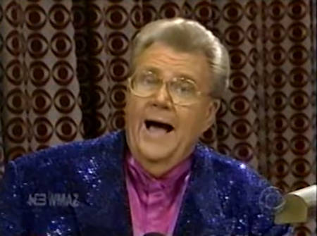 Rod is wearing a dark-blue sequined jacket & purple collarless silk shirt