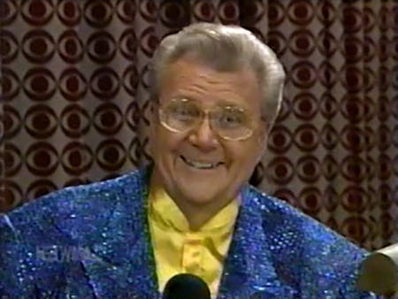 Rod is wearing a blue sequined jacket & yellow collarless silk shirt