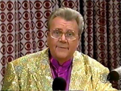 Rod is wearing a gold-sequined jacket & purple collarless silk shirt