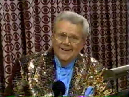 Rod is wearing a bronze sequined jacket & light-blue collarless silk shirt with matching pocket square