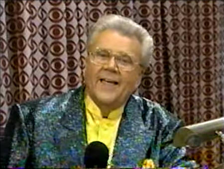 Rod is wearing a dark-green sequined jacket & yellow collarless silk shirt with matching pocket square