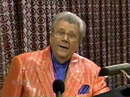 Rod is wearing a salmon sequined jacket & dark-blue collarless silk shirt with matching pocket square