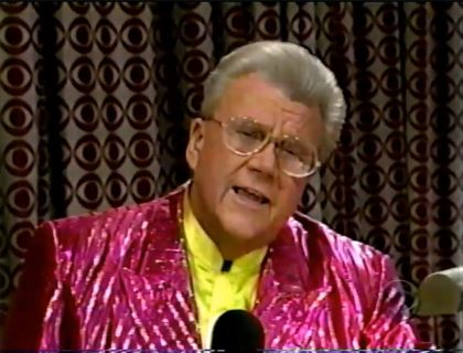Rod is wearing a shiny pink/pink-striped jacket & yellow collarless silk shirt