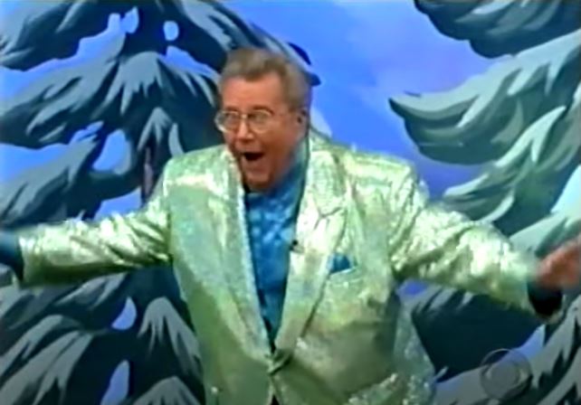 Rod is wearing a green sequined jacket & teal blue collarless silk shirt with matching pocket square