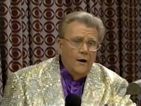 Rod is wearing a gold sequined jacket & purple collarless silk shirt