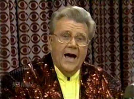 Rod is wearing a brown sequined jacket & yellow collarless silk shirt