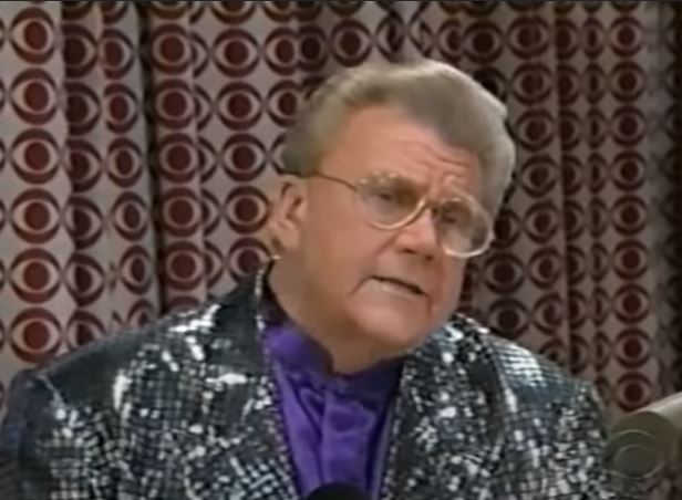 Rod is wearing a silver sequined jacket & purple silk collarless shirt