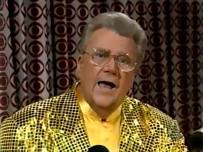Rod is wearing a yellow jacket with black sequins & yellow collarless silk shirt