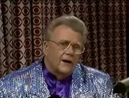 Rod is wearing a silver sequined jacket & purple collarless silk shirt