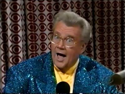 Rod is wearing a blue-green sequined jacket & yellow collarless silk shirt