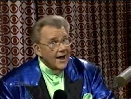 Rod is wearing a shiny blue jacket with black lapels & a lime-green collarless silk shirt with matching pocket square