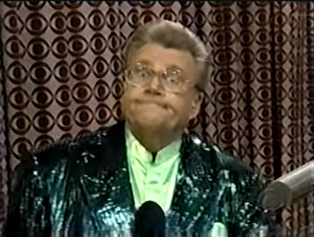 Rod is wearing a dark-green sequined jacket & mint-green collarless silk shirt with matching pocket square